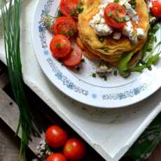Przepis na Wytrawny puszysty omlet z pomidorami, serkiem feta oraz garścią zieleniny.