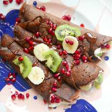 Przepis na Orkiszowe, czekoladowe naleśniki z bitą śmietaną, kiwi, bananami, ziarnami granatu i rozpuszczoną czekoladą