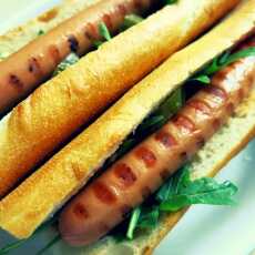 Przepis na Hot dog z grilla z kiszonym ogórkiem, rukolą i sosem