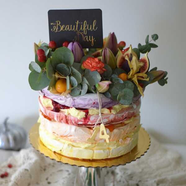 Urodzinowy tort bezowy z dekoracją z owoców i żywych kwiatów