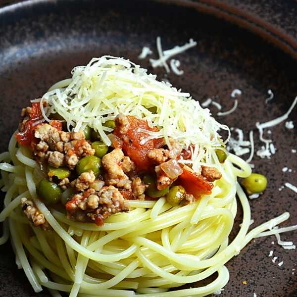 Makaron spaghetti z sosem pomidorowym, zielonym groszkiem i mieloną karkówką