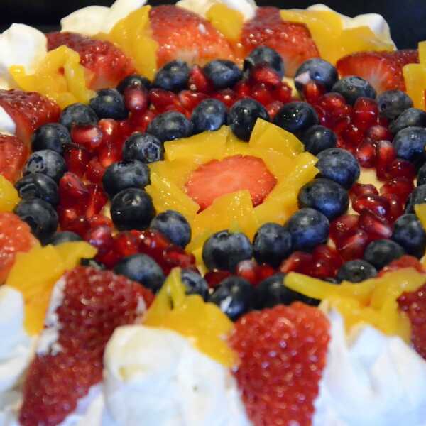 Tort urodzinowy z masą budyniową, owocami i bitą śmietaną 